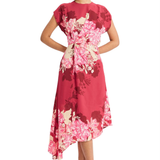 Model wearing a vibrant pink printed short-sleeve midi dress with an asymmetrical hem and flowing silhouette.