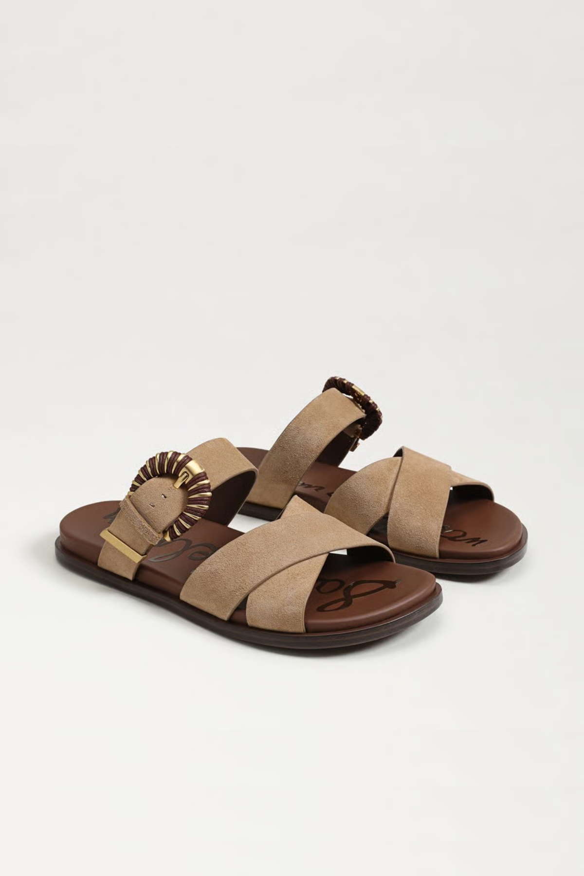 Pair of tan sandals with brown straps on a white background
