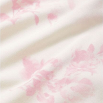 Close-up of a soft fabric with pink floral patterns on a white background