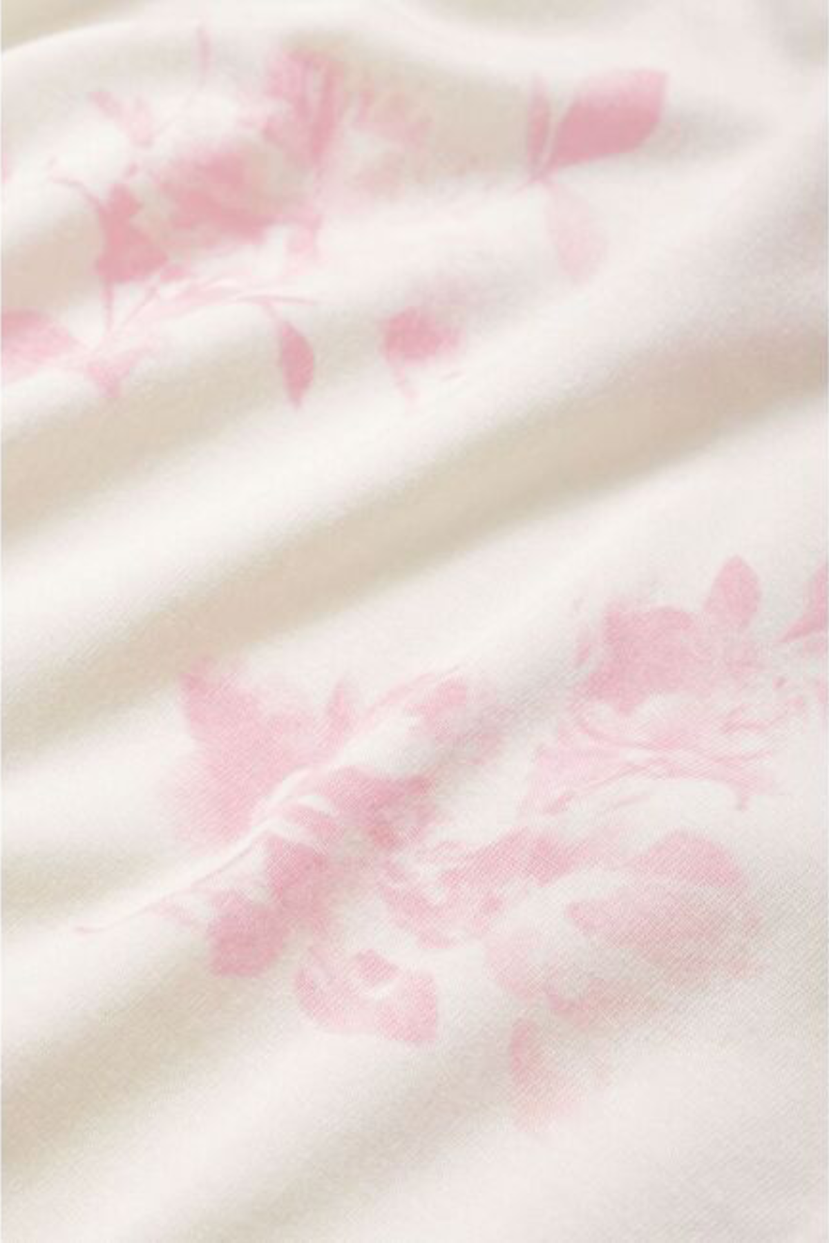 Close-up of a soft fabric with pink floral patterns on a white background