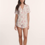 Woman wearing a floral pajama set on a plain background