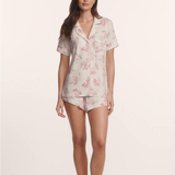Woman wearing a floral pajama set on a plain background