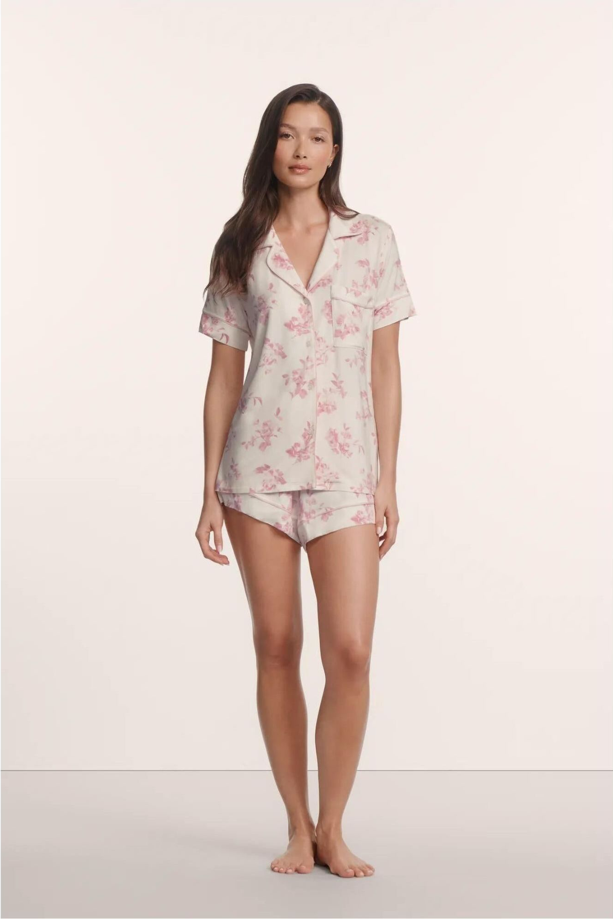 Woman wearing a floral pajama set on a plain background