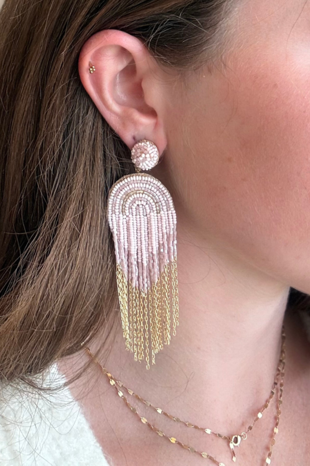 Model wearing beaded and chain detail earrings.