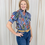 Woman wearing a short sleeve printed blouse in blue tones with an easy, relaxed fit