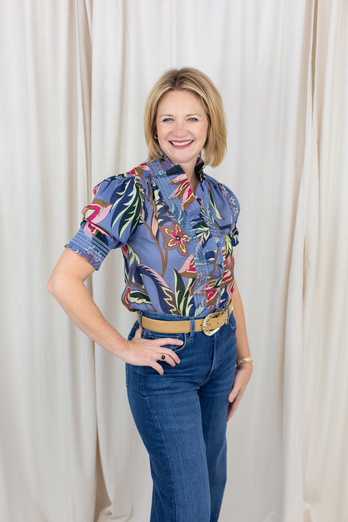 Woman wearing a short sleeve printed blouse in blue tones with an easy, relaxed fit