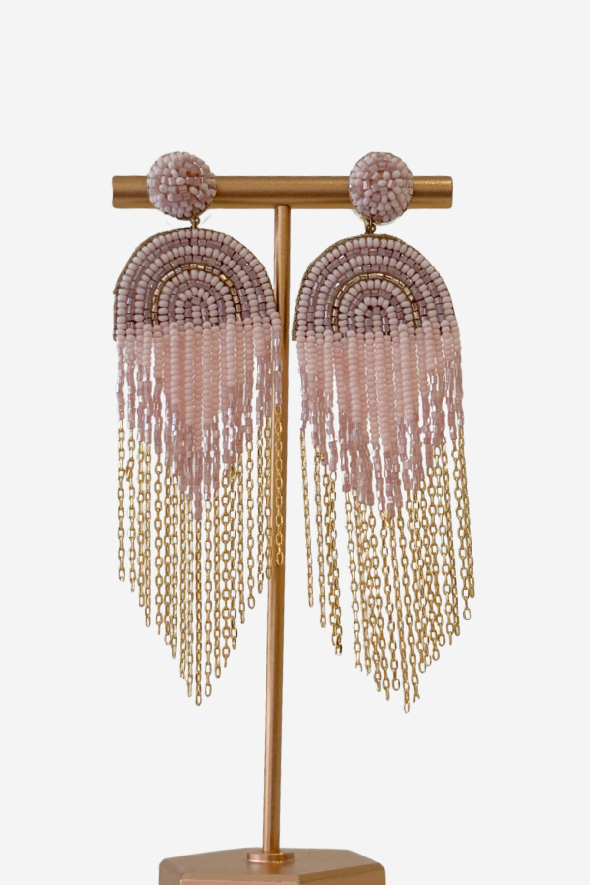 Beaded and chain detail earrings on gold stand featured on a white background.