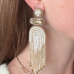 Model wearing gold beaded and chain detail drop earrings. 