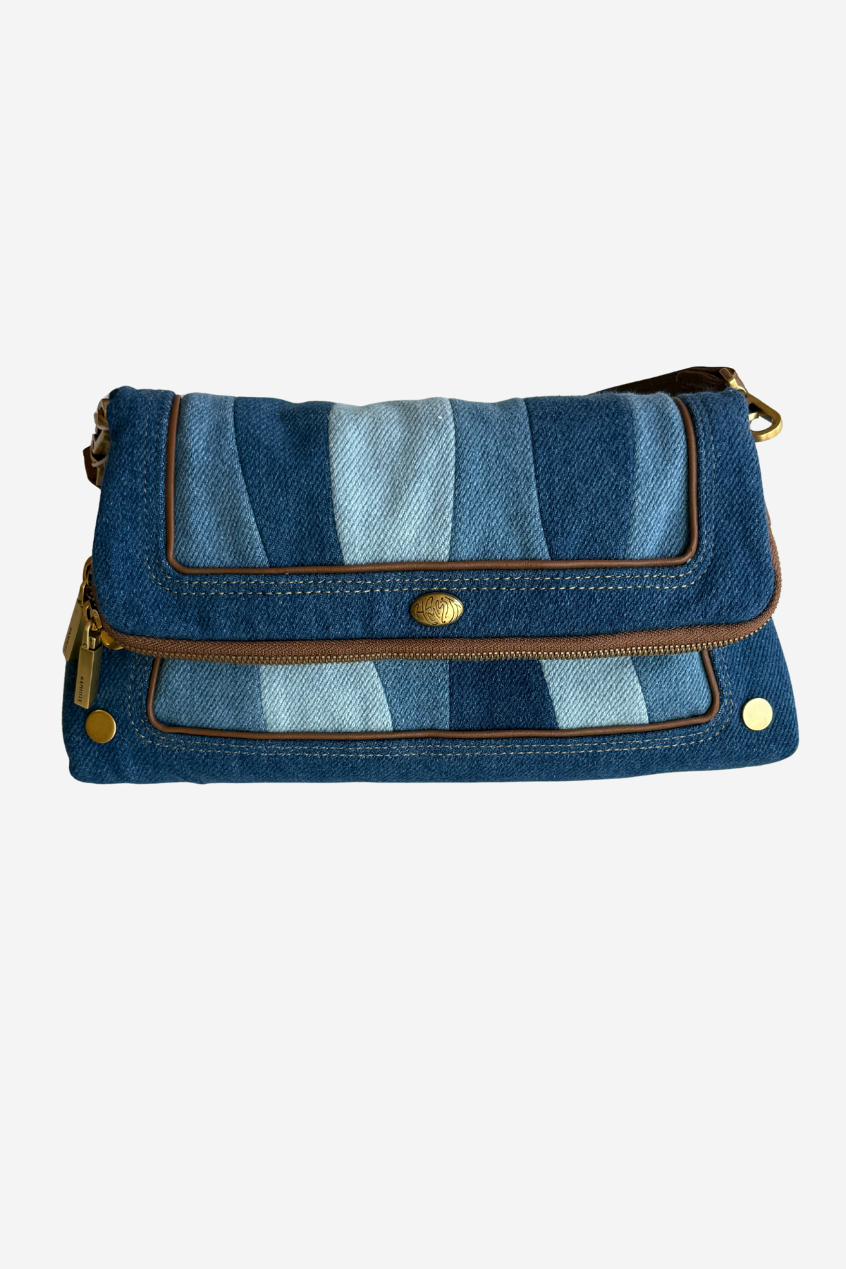 A blue denim crossbody bag with a striped pattern of light and dark blue denim panels, brown leather trim, and gold-tone hardware, shown against a plain white background.