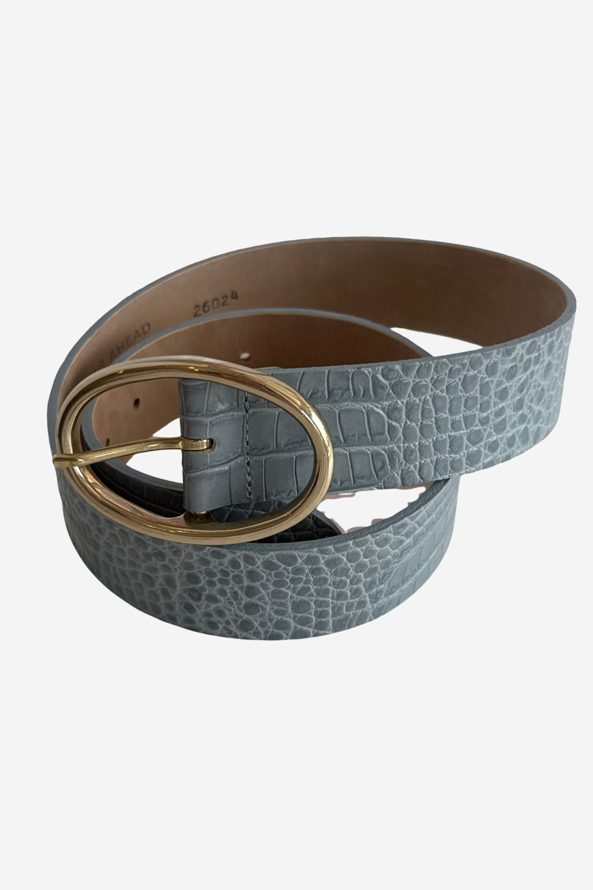 A light blue-gray crocodile-embossed leather belt with a large oval gold-tone buckle, coiled on a light gray background.