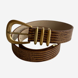 A brown textured leather belt with a gold-tone metal buckle and matching gold-tone decorative accents, coiled on a light gray background.