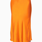Orange satin skirt worn by a person on a white background