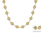 A gold-toned beaded necklace with round pearl-like beads connected by small metallic links, shown on a plain white background. A small inset in the lower right shows a water-resistant detail with the text 'Water-Resistant.