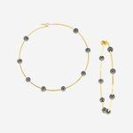 Gold hoops with dark gray beads on a light gray background.