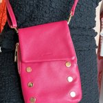 Model wearing hot pink crossbody bag with gold hardware. 