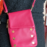 Model wearing hot pink crossbody bag with gold hardware. 