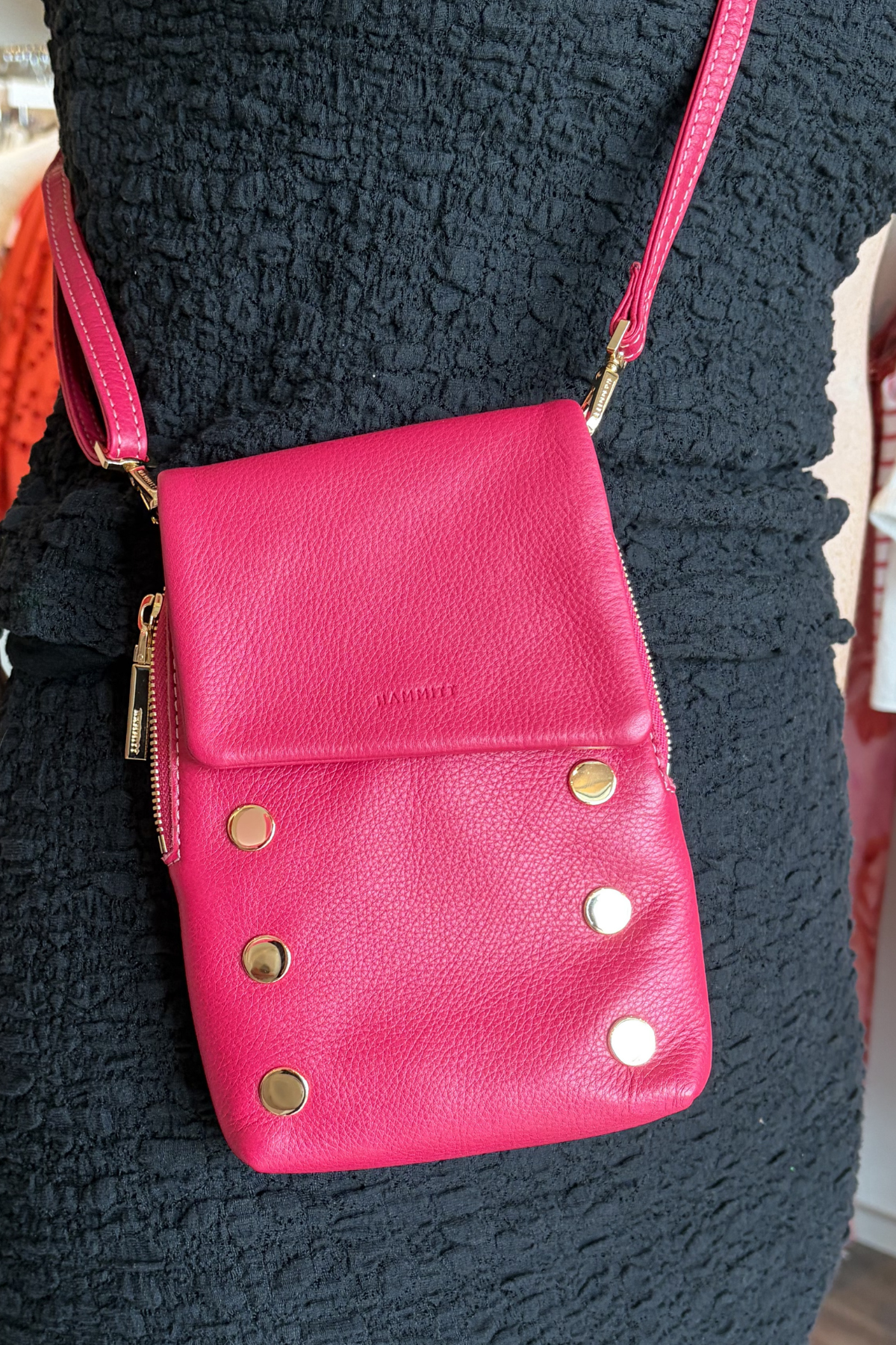 Model wearing hot pink crossbody bag with gold hardware. 