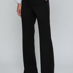 Person wearing black wide-leg pants with a white shirt on a light gray background