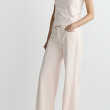 Person wearing a light pink t-shirt and wide-leg pants on a white background