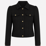 A black cropped jacket with structured shoulders, a pointed collar, flap chest pockets, and gold-tone buttons, shown on a plain light gray background.