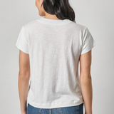 Person wearing a plain white t-shirt and blue jeans on a light gray background