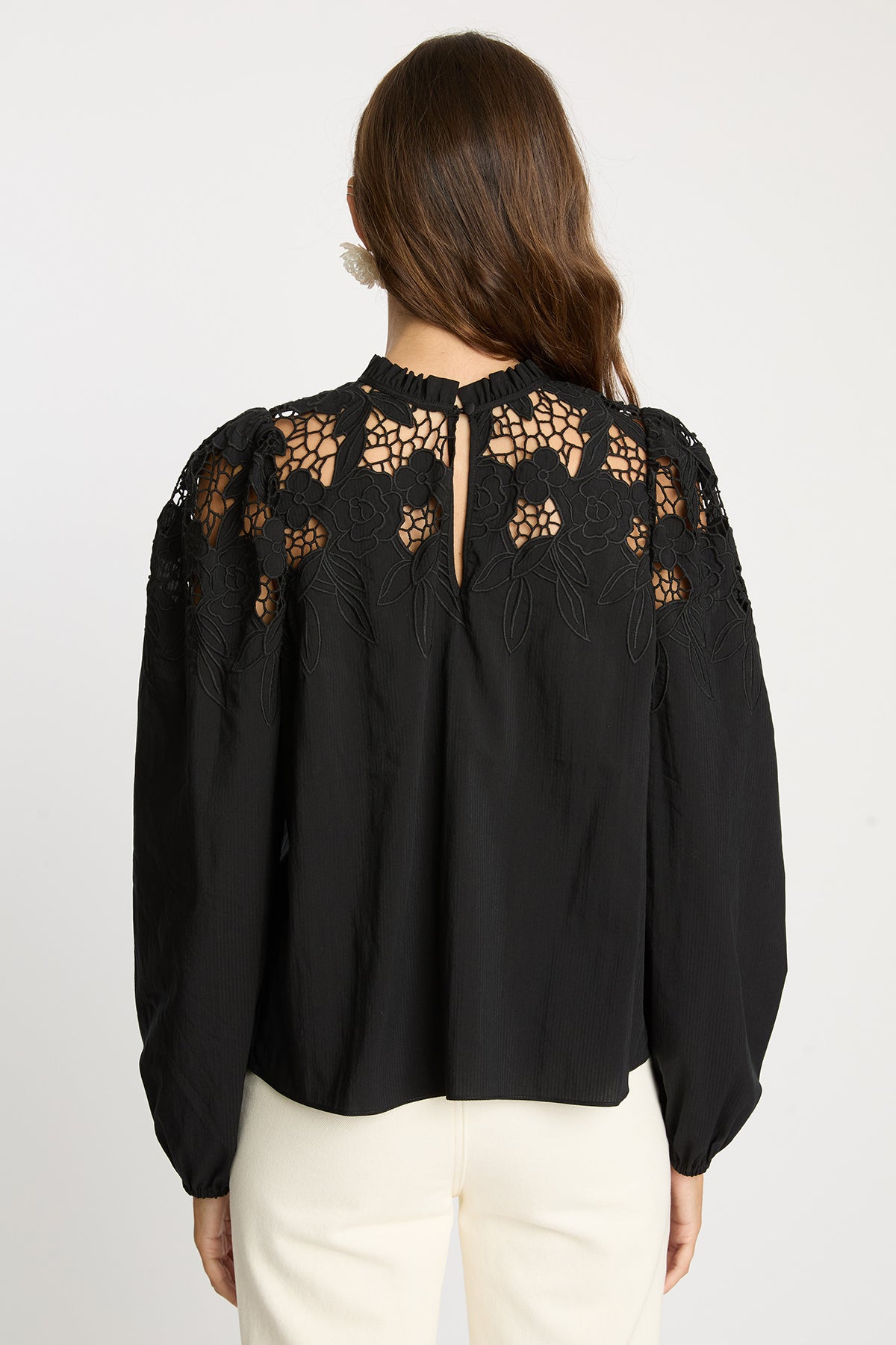 Black blouse with lace details on a white background
