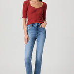 Woman wearing mid-wash straight-leg jeans with a streamlined, classic silhouette.