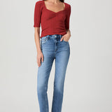 Woman wearing mid-wash straight-leg jeans with a streamlined, classic silhouette.