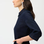 Woman wearing a indigo denim  dress with a belt on a white background