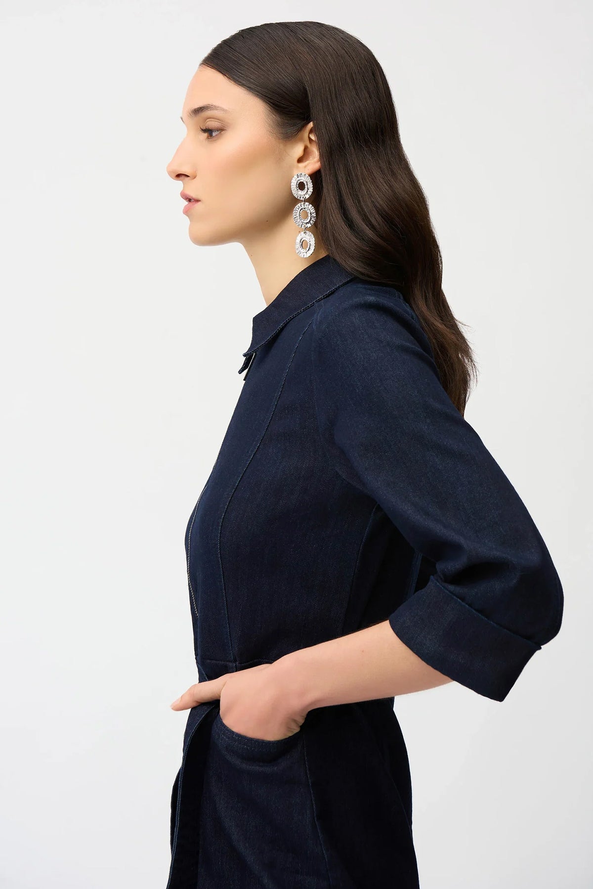 Woman wearing a indigo denim  dress with a belt on a white background