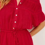 Red dress with white buttons on a plain background