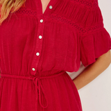 Red dress with white buttons on a plain background