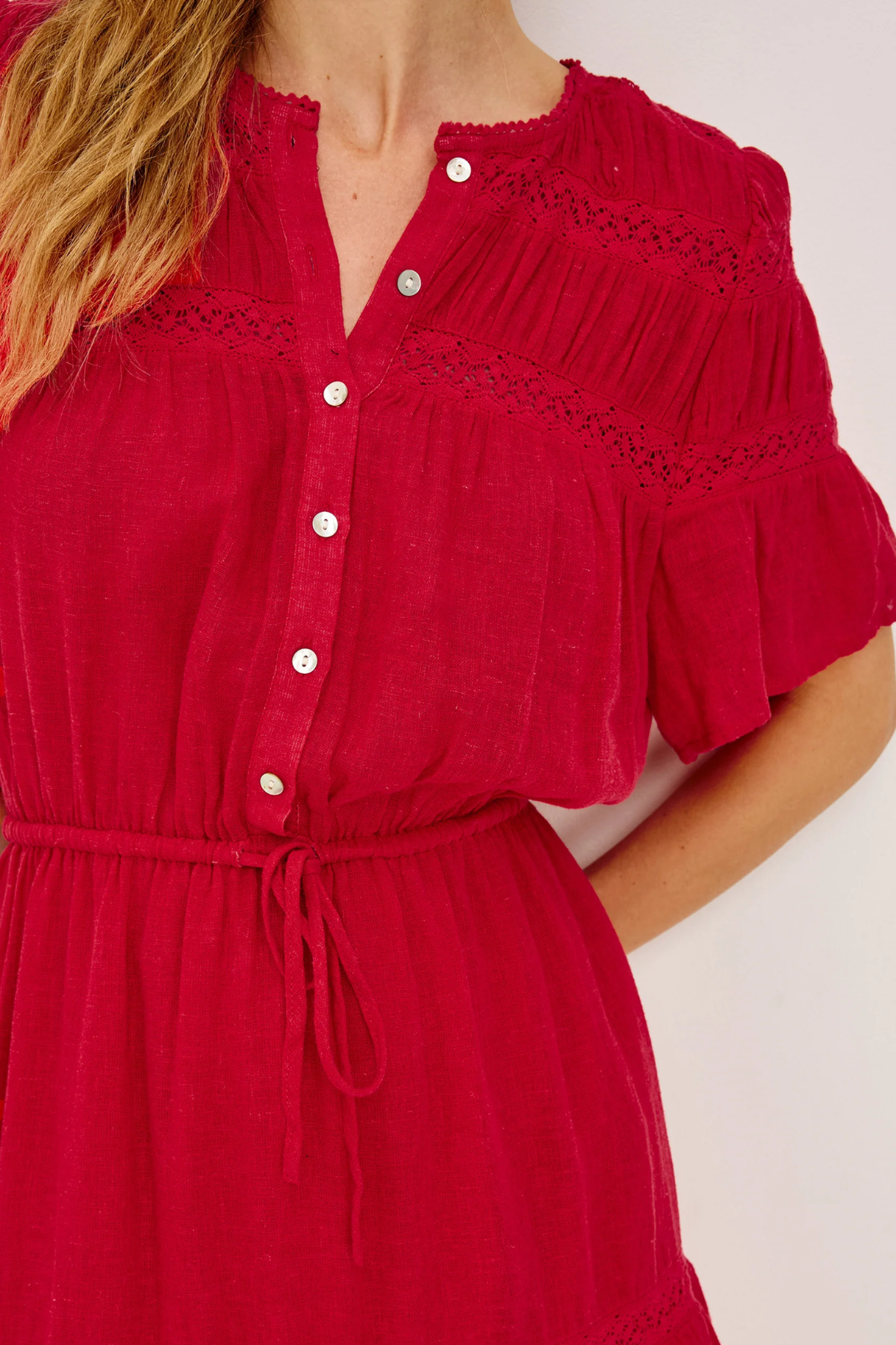 Red dress with white buttons on a plain background