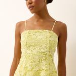 yellow lace top on woman infront of a white background 