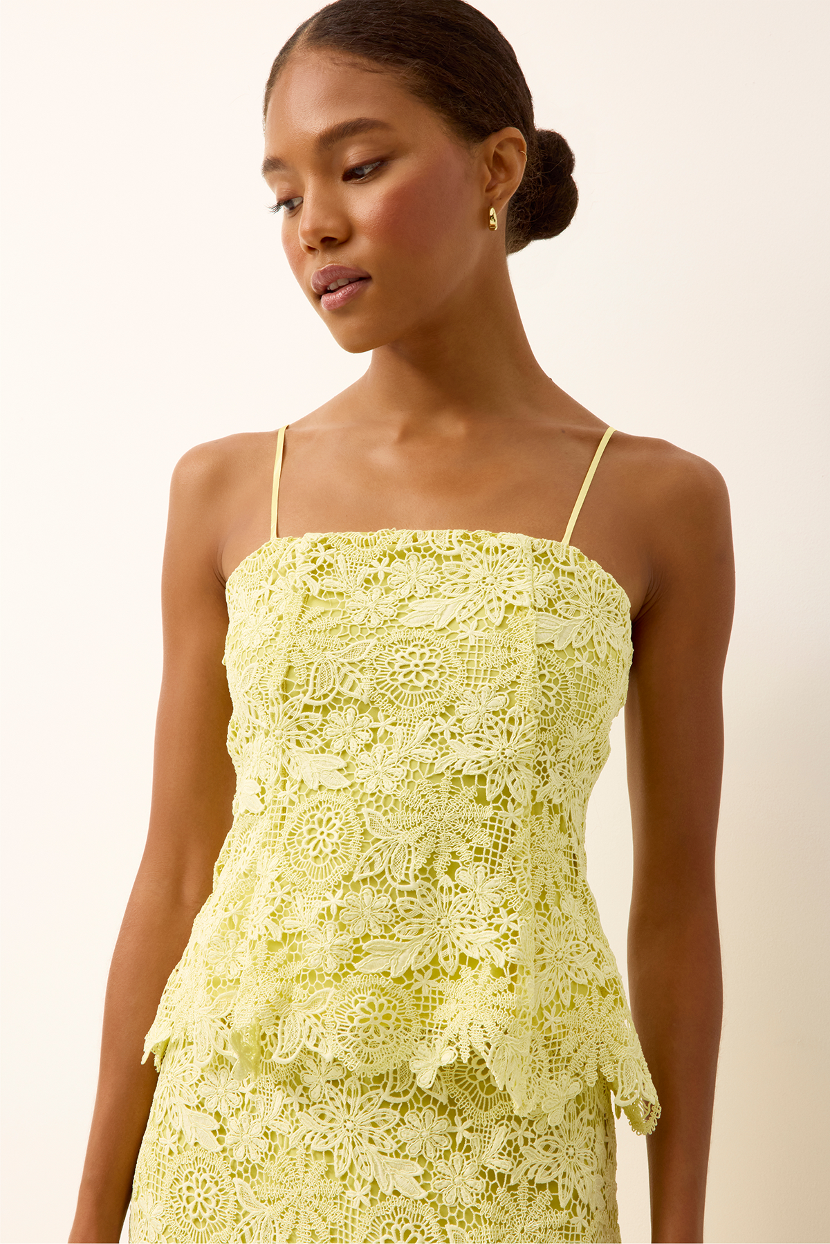 yellow lace top on woman infront of a white background 