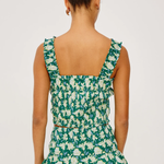 Woman wearing a green floral dress on a white background