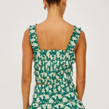 Woman wearing a green floral dress on a white background