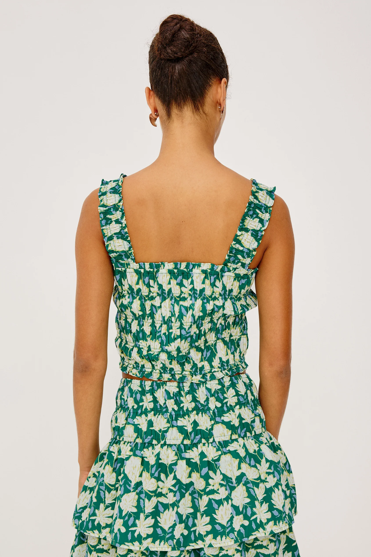 Woman wearing a green floral dress on a white background