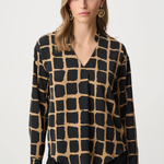 Woman wearing black and gold patterned top against a white background