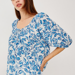 woman in blue printed blouse on white background 