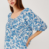 woman in blue printed blouse on white background 