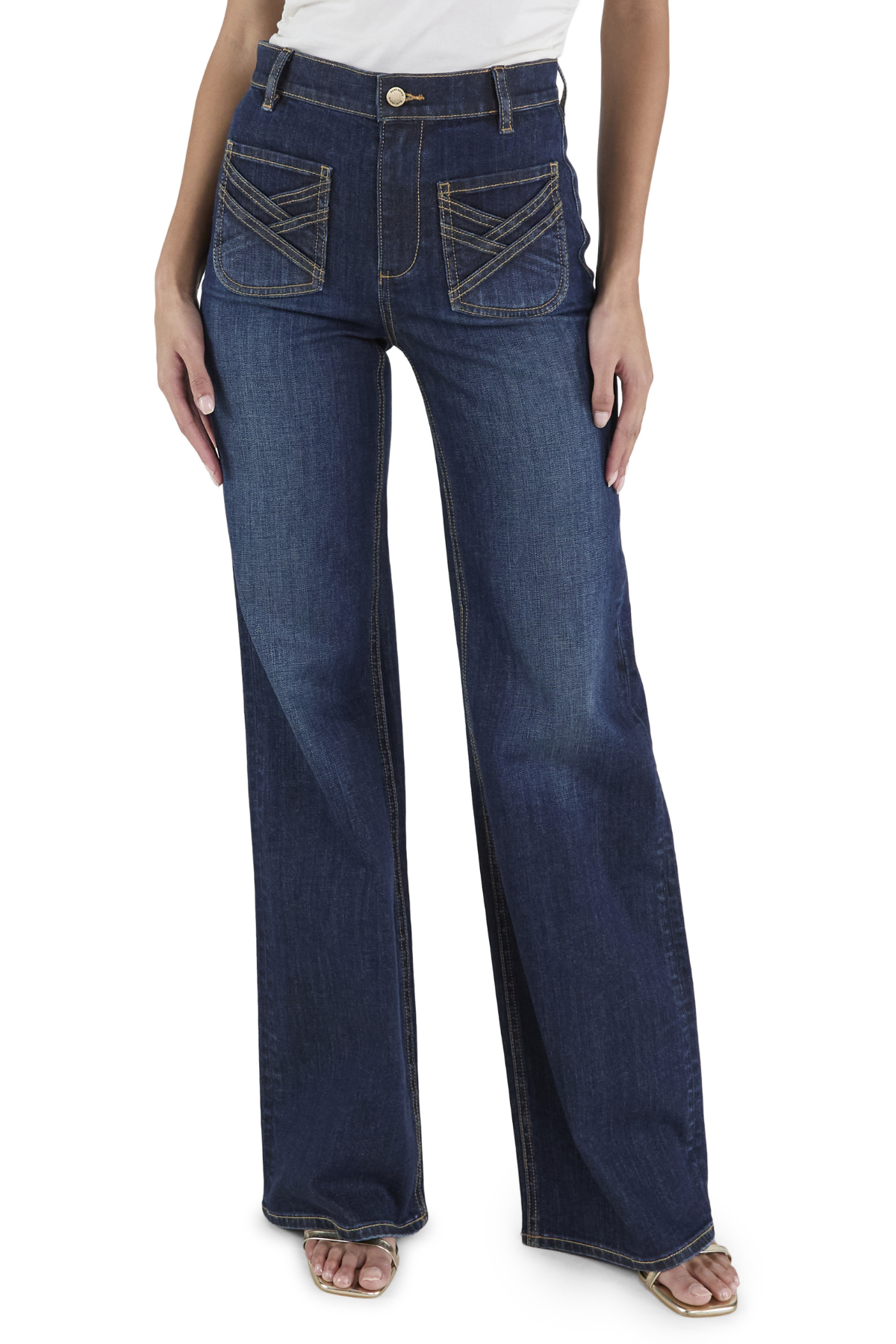 A model from the waist down wearing dark blue wide-leg denim jeans with decorative contrast stitching on the back pockets, paired with a white top and flat sandals, against a plain white background.