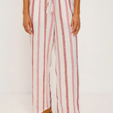 Person wearing a striped outfit with wide-leg pants on a white background