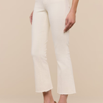 White pants worn by a person on a beige background