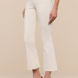 White pants worn by a person on a beige background