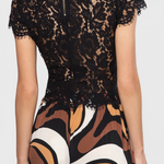 Black lace top worn by a person with a white background