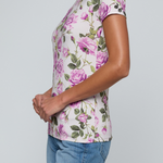 Model wearing rose print tee on a white background.
