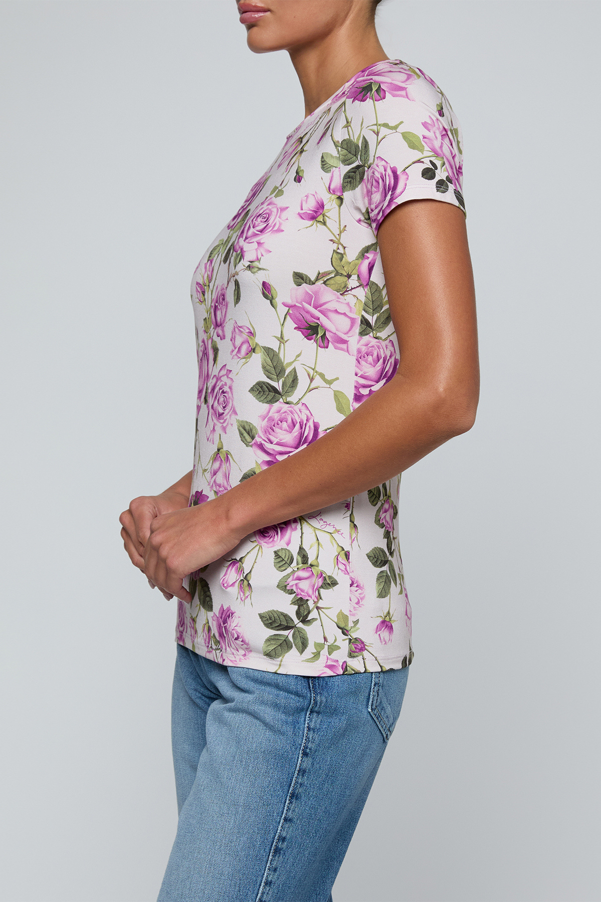 Model wearing rose print tee on a white background.