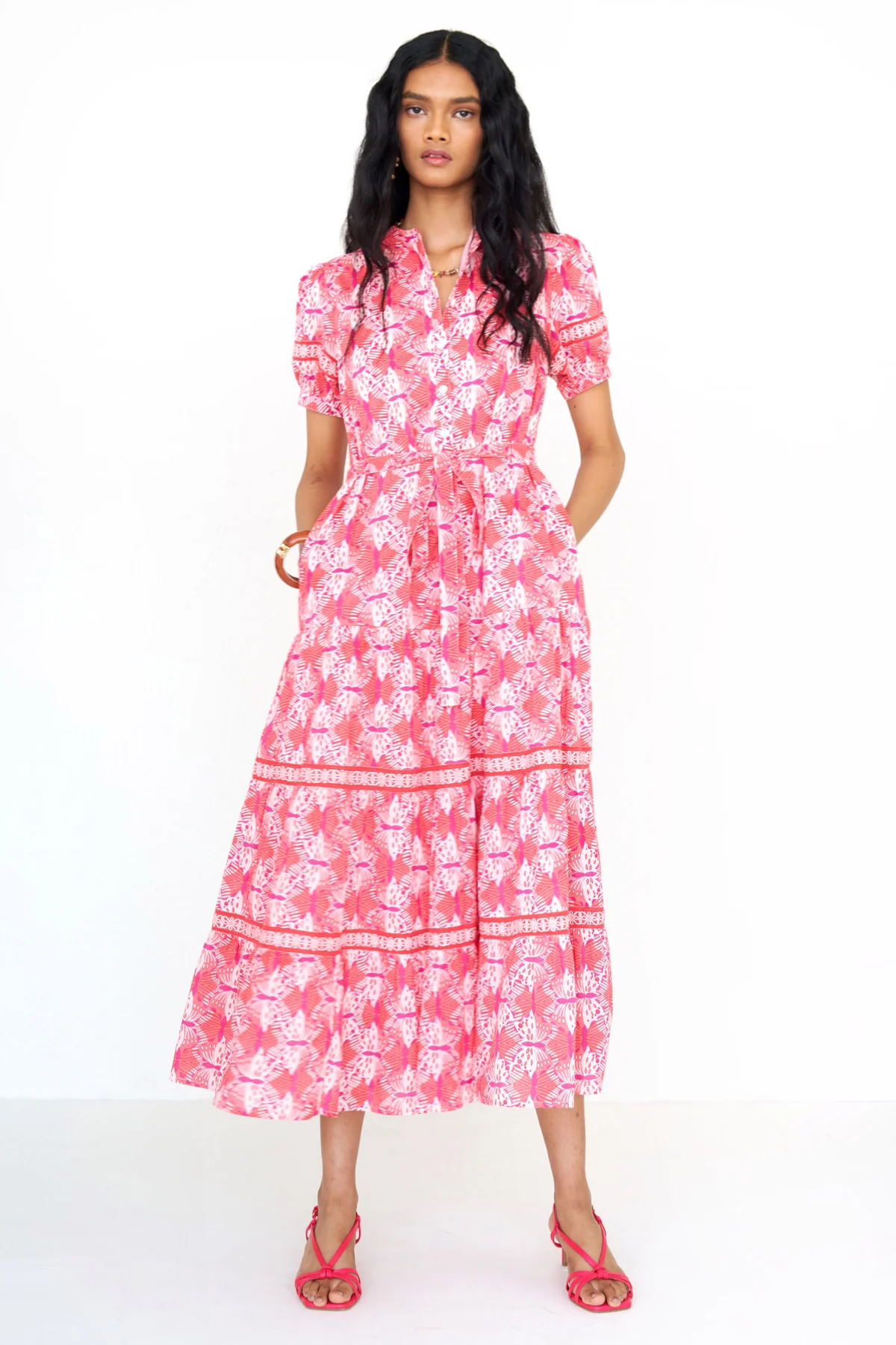 Woman wearing a pink floral dress on a white background