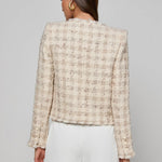 Collarless tailored jacket in a neutral tone, styled over a lightweight top